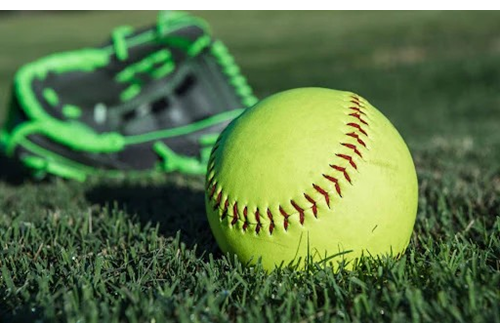 softball on grass with green glove